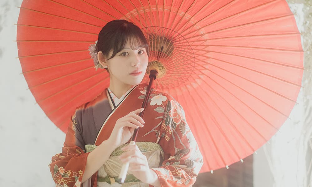スタジオハイタッチで成人記念の写真を撮る傘をさす女性